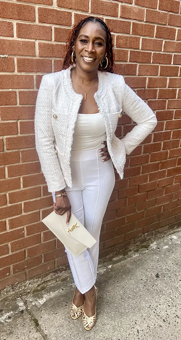 Breast cancer survivor and PCOM clinical psychology graduate Keena Stewart, PsyD '25, smiles in front of a brick wall
