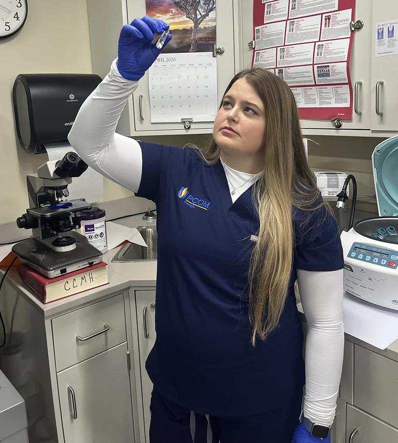 Medical laboratory science program graduate Leslie Walden, MS/MLS '26, examines a test tube in a laboratory