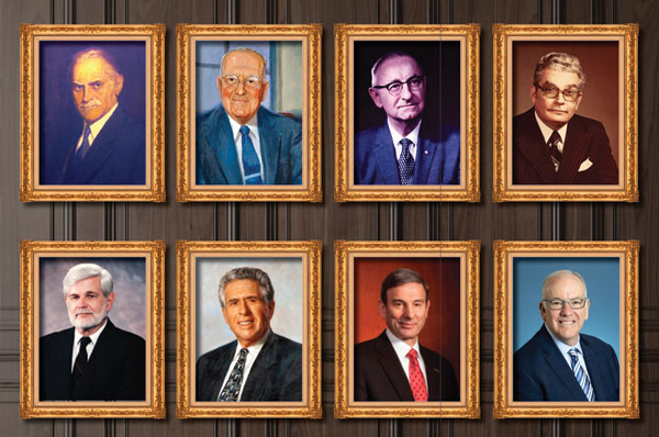 Portraits of PCOM presidents hanging in brass frames on a wood panel wall