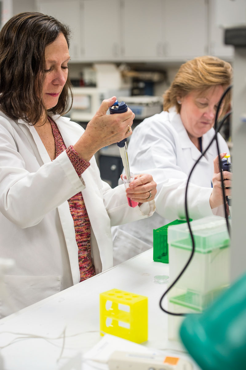 Mindy George-Weinstein, PhD, works with a colleague in a PCOM lab