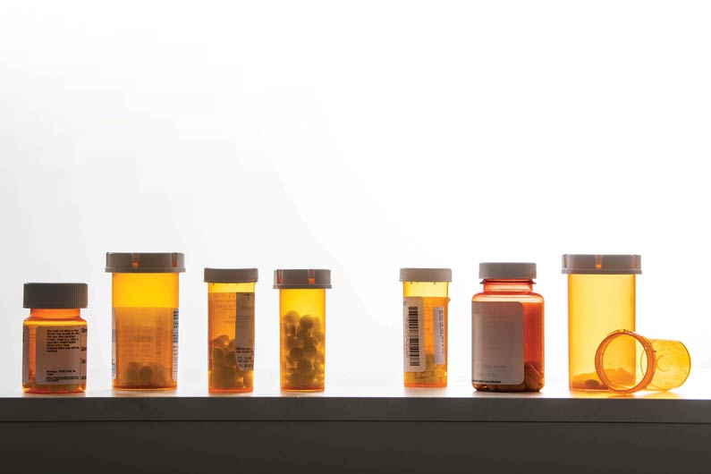 Photograph of pill bottles on a medicine cabine shelf
