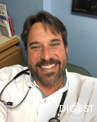 Jeremy A. Dubin, DO '02, FASAM, smiling in his physician office