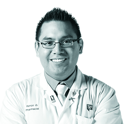 Black and white professional headshot photograph of Renzo Gonzalez, PharmD ’16, smiling and wearing his pharmacist white coat