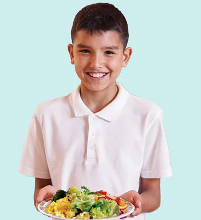 Young boy holds plate of healthy foods
