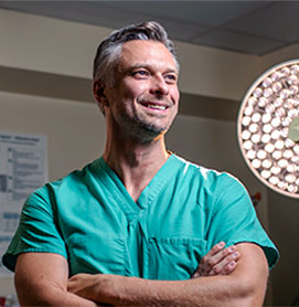 Photograph of Marcin Jankowski, DO '05, in his scrubs in a hospital room.