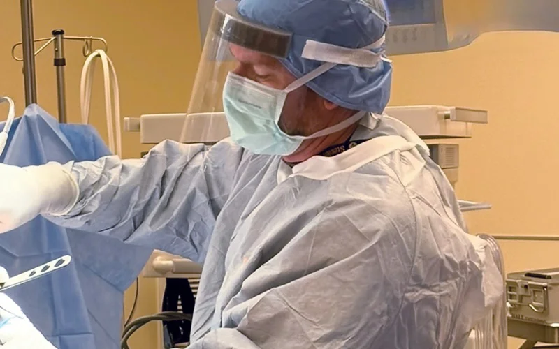 Surgeon in operating room wearing mask and scrubs