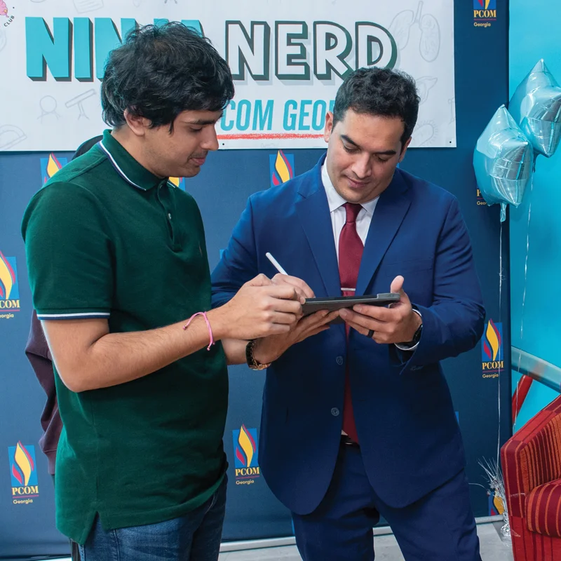 Zach Murphy, aka Ninja Nerd, signs an autograph for a PCOM student