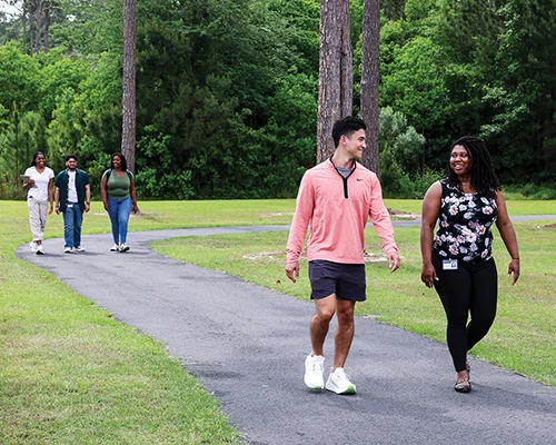 Students walk along the PCOM South Georgia walking trail on an overcast afternoon
