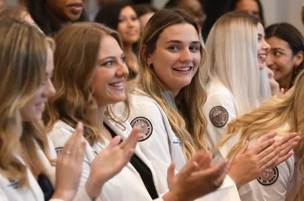 PCOM Georgia physician assistant studies students clap and smile during a white coat ceremony event