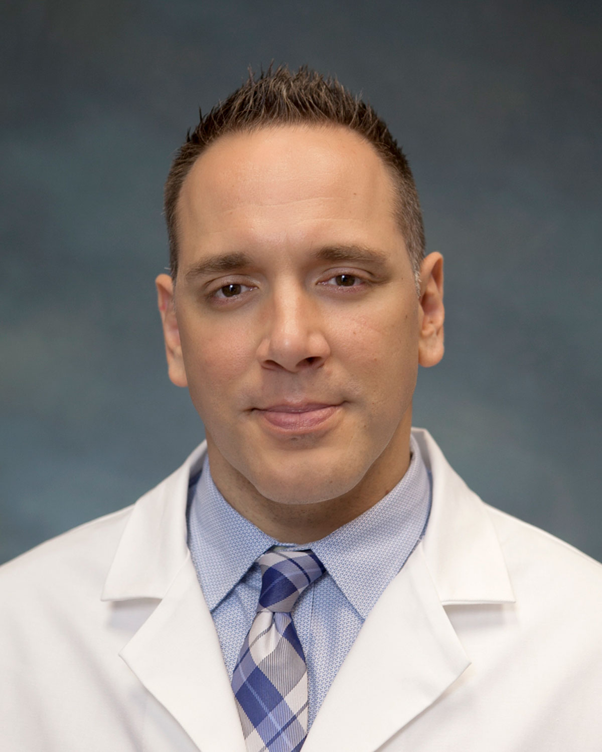 Professional headshot photo of Robert Bassett, DO '06, FAAEM, FCPP, wearing a physician white coat