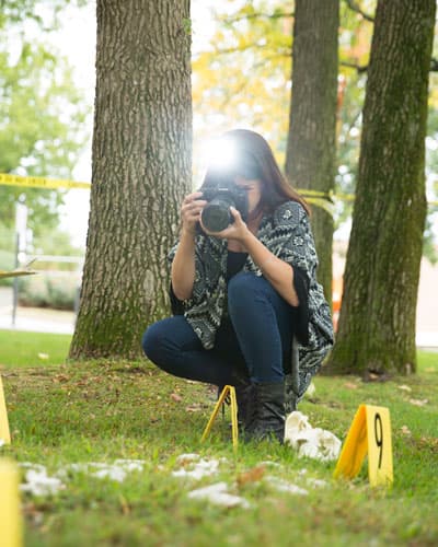 PCOM forensic medicine student takes photos at a simulated crime scene
