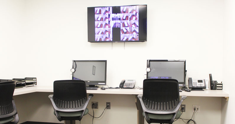 Simulation control room with computers, monitors and wall-mounted screens at PCOM Georgia