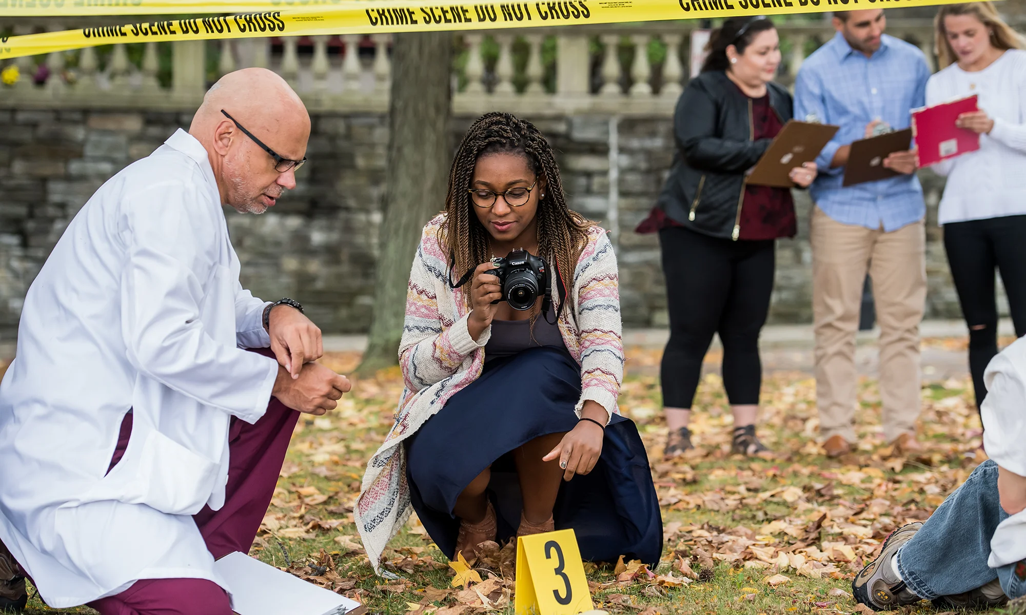 Forensic medicine concentration students taking photos and notes during a mock crime scene investigation exercise