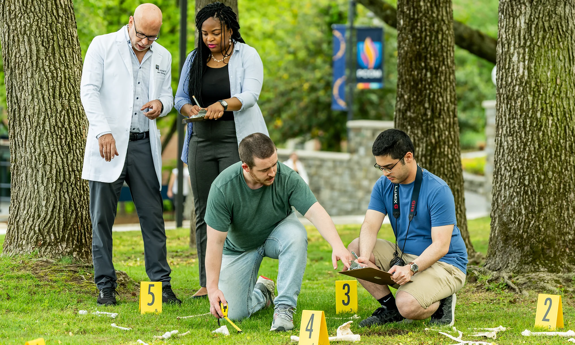 Forensic medicine students work on a hands-on learning exercise outside at PCOM