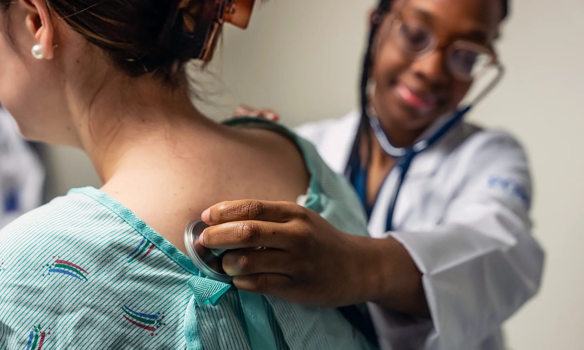 A physician at PCOM Family Medicine practice uses a stethoscope to examine a patient