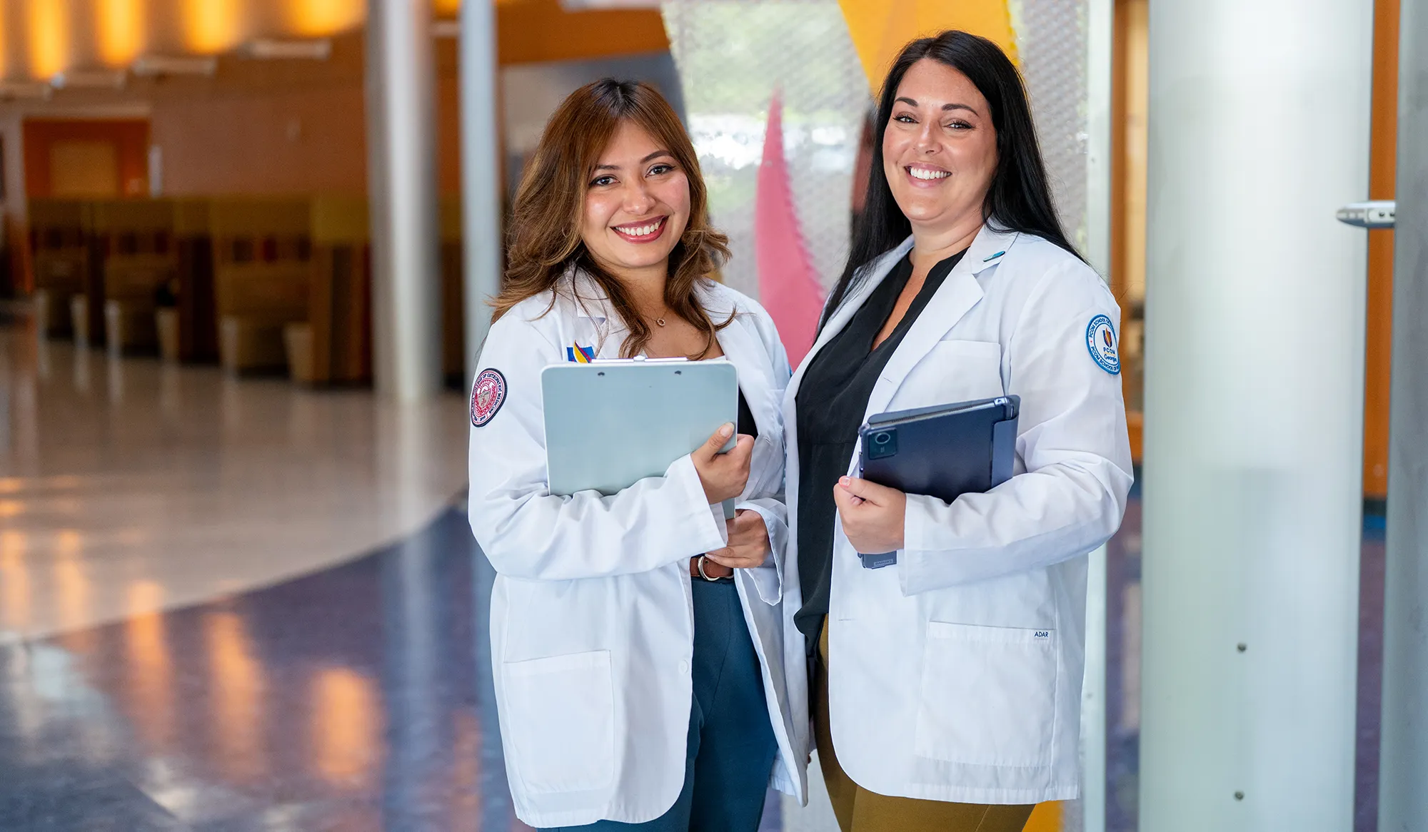 Two PCOM Georgia medical students smiling in the lobby