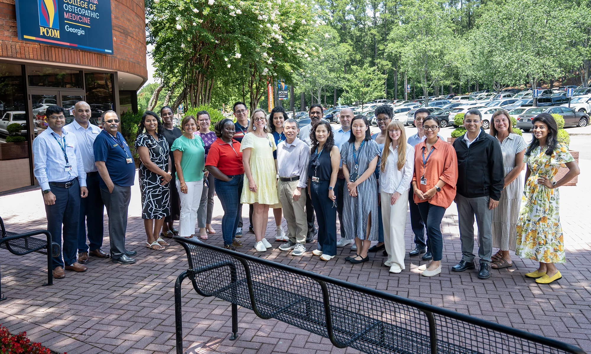 School of Pharmacy faculty and staff smiling in a group photo outside at PCOM Georgia