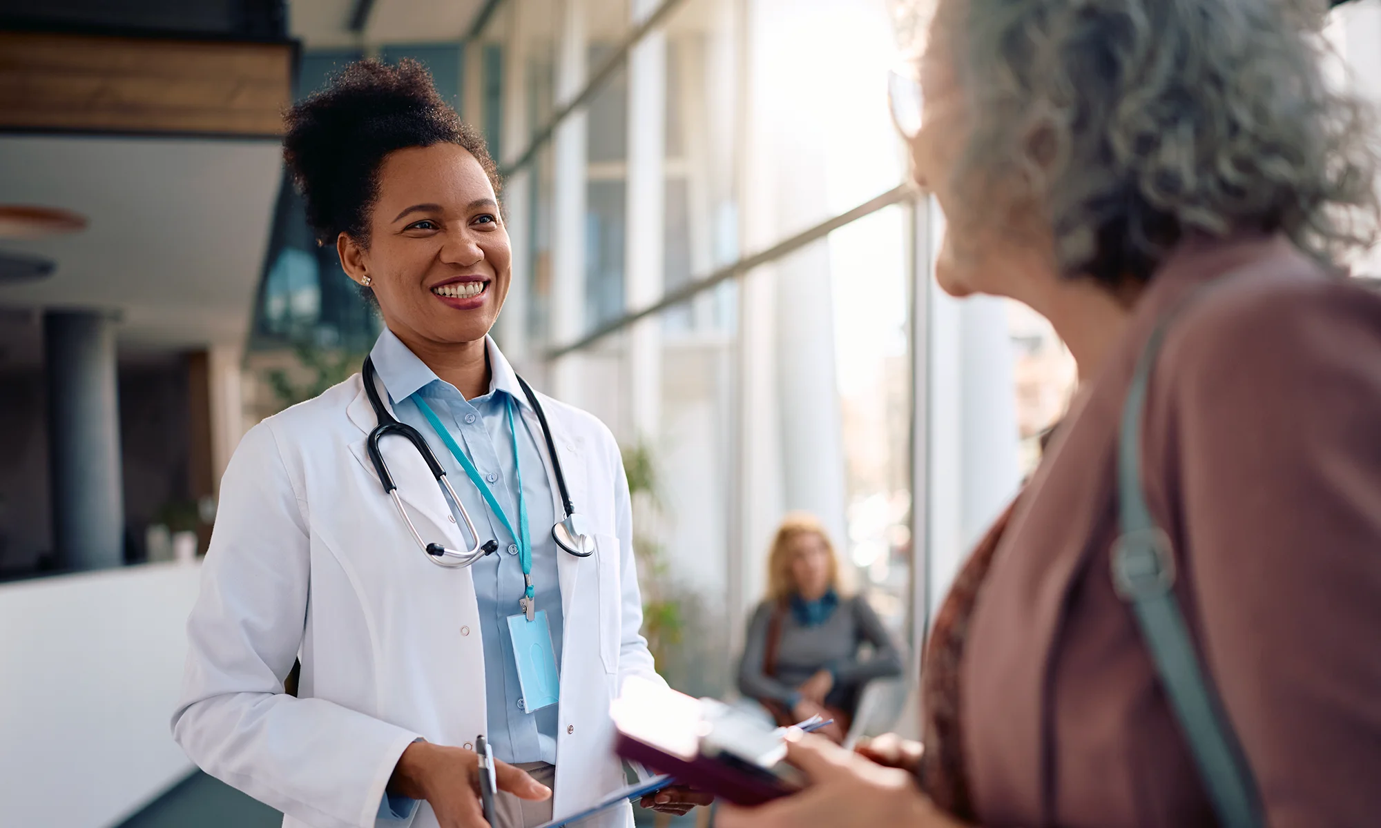 A PCOM faculty member who is also a researcher and physician speaking with a patient