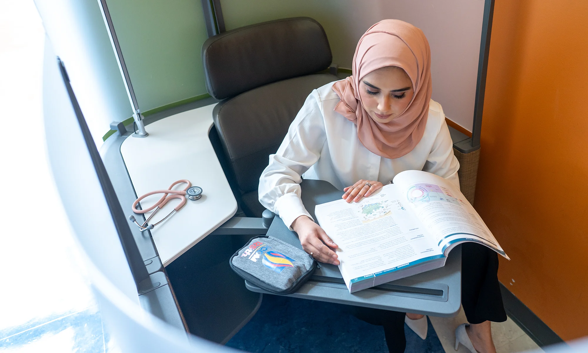 PCOM Georgia medical student reading a textbook in a study pod