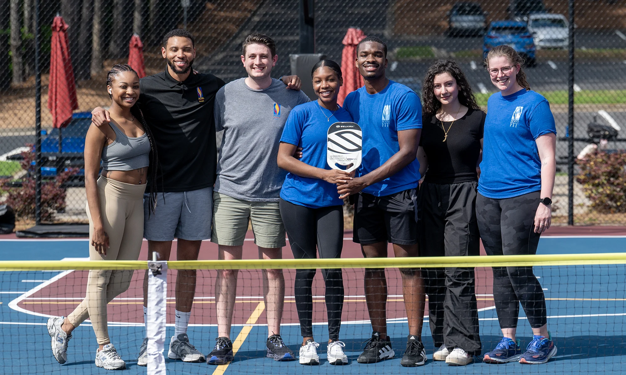 PCOM Georgia students smiling in a group on the outdoor pickleball court