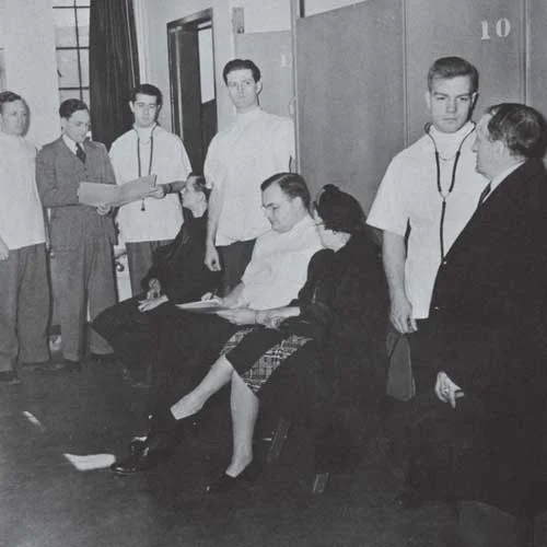 Black and white photo of medical students examining patients during the 1930s