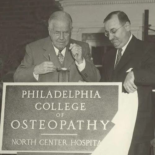 Black and white photograph of PCOM administrators unveiling a plaque reading "Philadelphia College of Osteopathy - North Center Hospital"