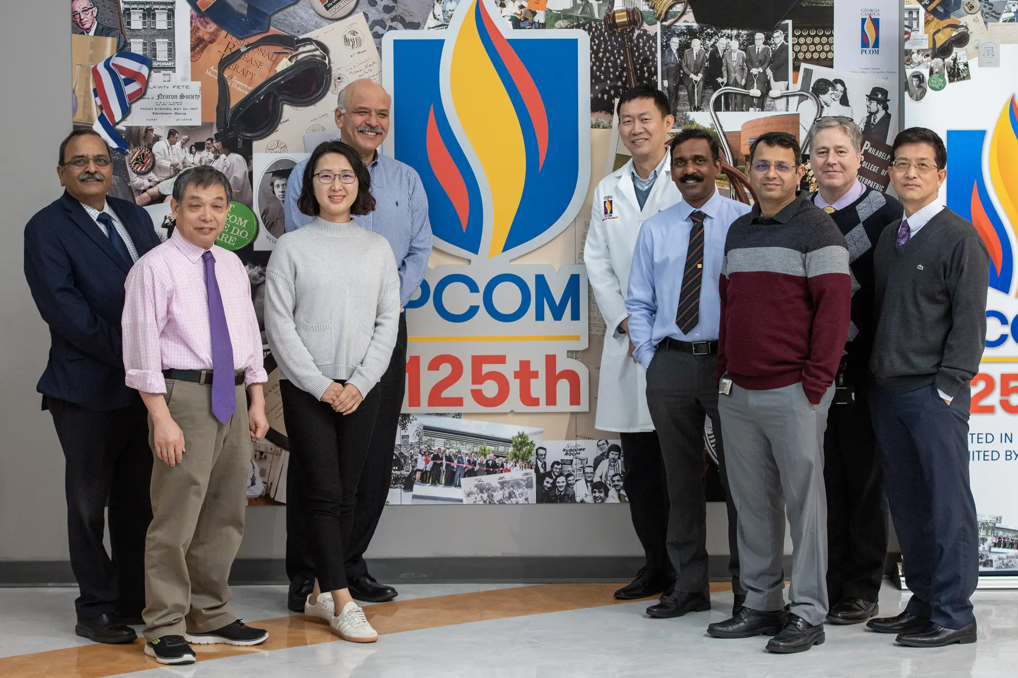 Four grad students smiling on front of the PCOM 125th anniversary collage