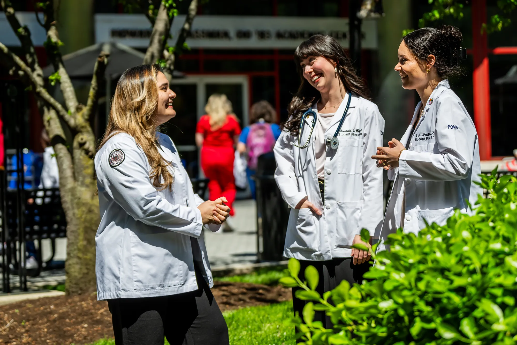 Medical students smile and talk in a courtyard outside Philadelphia College of Osteopathic Medicine's main campus