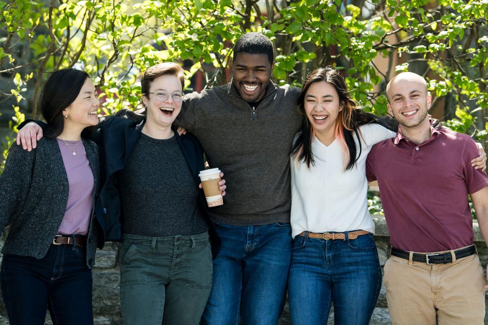 Five PCOM graduate and medical students smile outside in a garden on the Philadelphia campus.