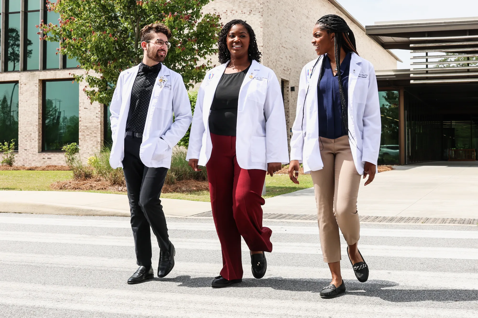 Medical students smile and talk in a courtyard outside Philadelphia College of Osteopathic Medicine's main campus