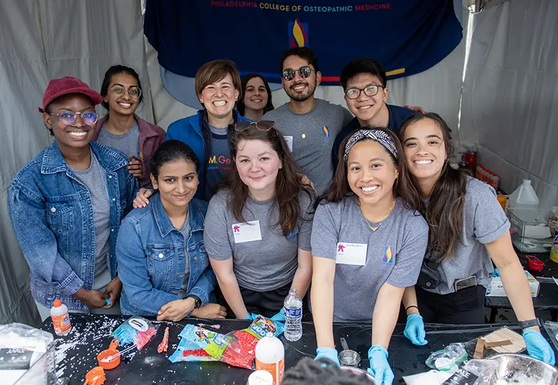Faculty and students smile inside a tent at the annual science festival