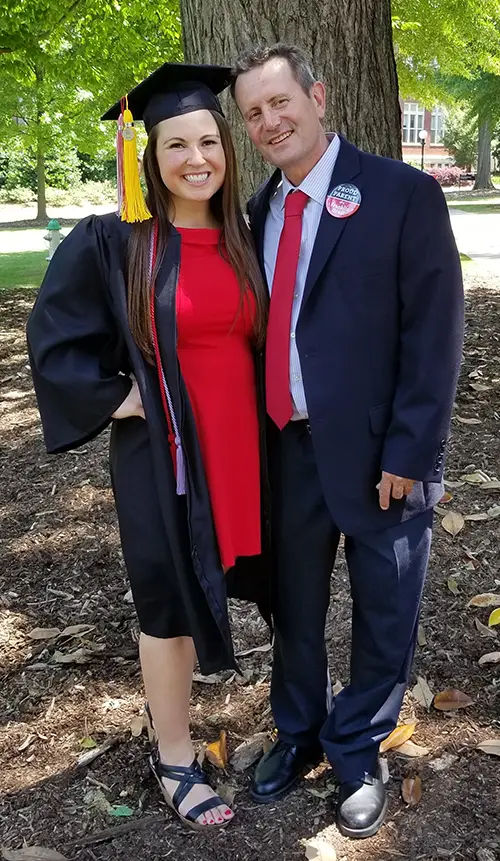 PCOM Georgia med student Janine Kfouri smiles alongside her late father in cap and gown during her undergraduate commencement