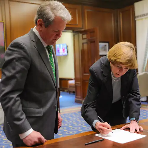 Linda Adkison, MS, PhD, signs documentation during her swearing-in ceremony at the Georgia State Capitol