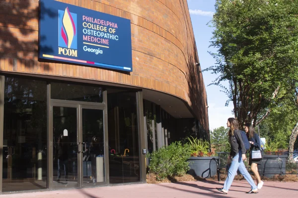 Students walking into the PCOM Georgia campus main entrance