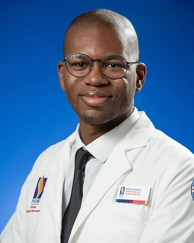 Professional headshot of Justice Sconiers (PharmD ‘27) wearing PCOM white coat