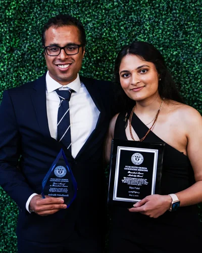 Anirudh Veludhandi and Riya Patel accepting awards