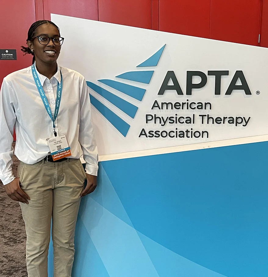 Te’Jayah Jones (DPT '28) posing next to an American Physical Therapy Association (APTA) sign