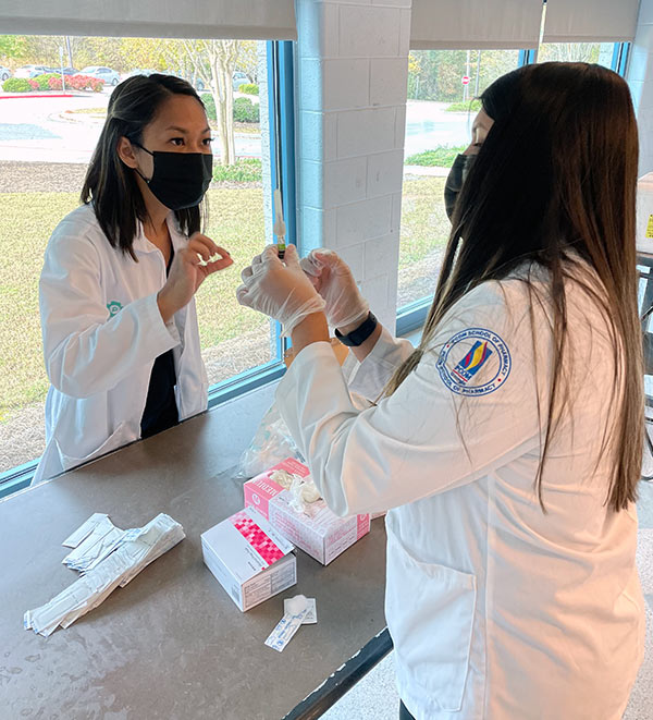 Pharmacy students volunteer to help administer flu shots in the surrounding communities