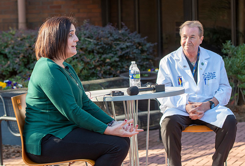 Rachelle Broom and Dr. Donald Penney talk outside of PCOM Georgia as she shares and thanks him for saving her life