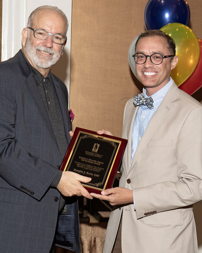 Dr. Jay Feldstein presents Douglas J. Koch, EdD, with a plaque