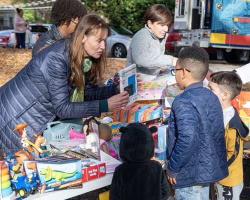 Faculty members distribute toys to children in Sarah Gonzalez Park