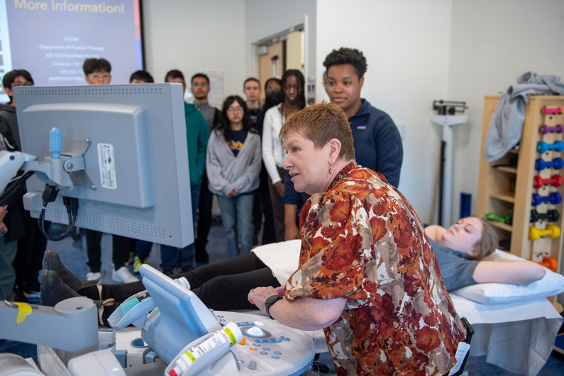 Professor demonstrates ultra sound equipment for high school students