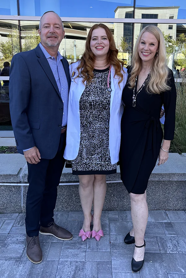PCOM Georgia medical student Lucy Fisher smiling with her parents after the DO program's white coat ceremony event