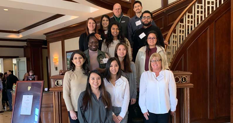 PCOM Georgia students, alumni and faculty take a group photograph on a staircase at the GSHP Committee Day.