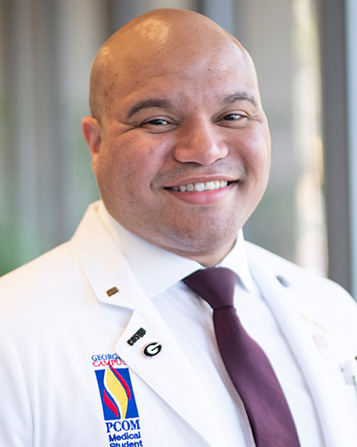 Professional headshot photograph of medical student Abdul Walters (DO '20) wearing his white coat.