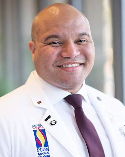 Professional headshot photograph of Abdul A. Walters, MS/Biomed '16 (DO '20), weaing his student physician white coat