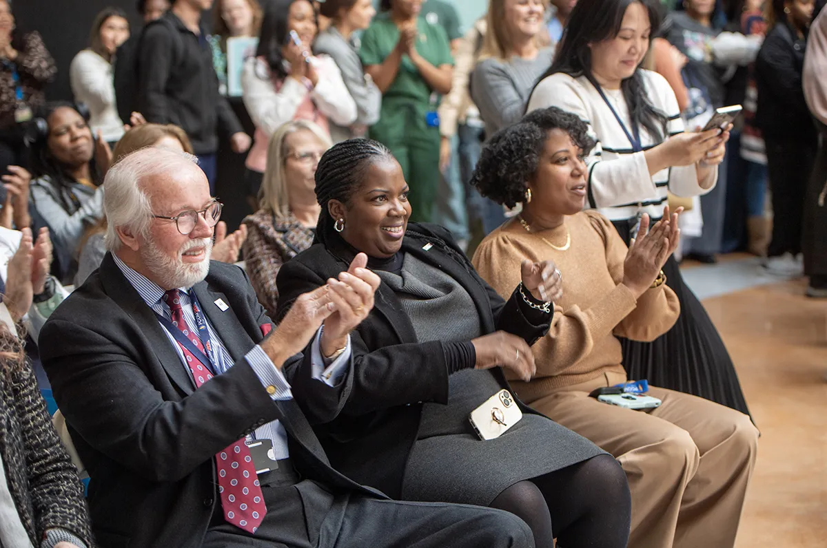 PCOM Georgia students and staff clap during the DNA art wall unveiling ceremony