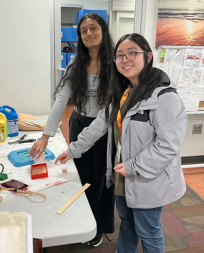 Seniors from Gwinnett School of Mathematics, Science, and Technology smile while working with equipment in the PCOM Georgia Simulation Center as part of the internship program
