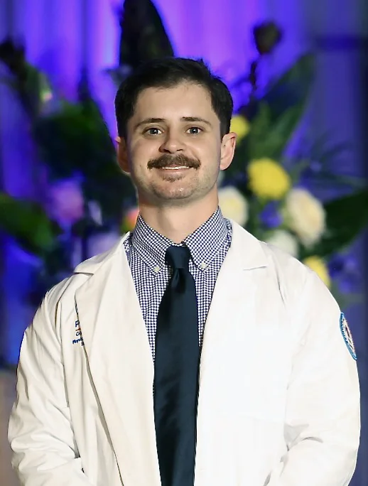 Headshot photograph of PCOM Georgia physical therapy student Reese Stokes (DPT '27) donning his student white coat