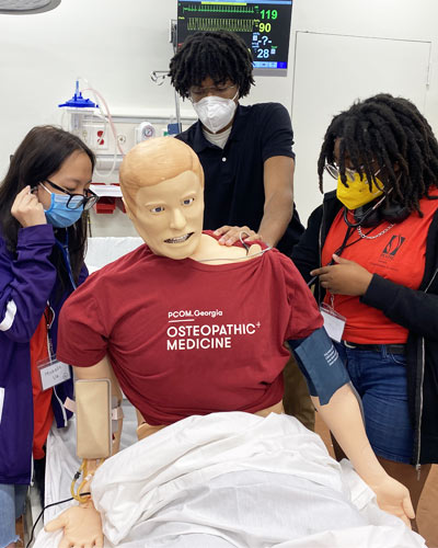 High school students practice treating a human patient simulator